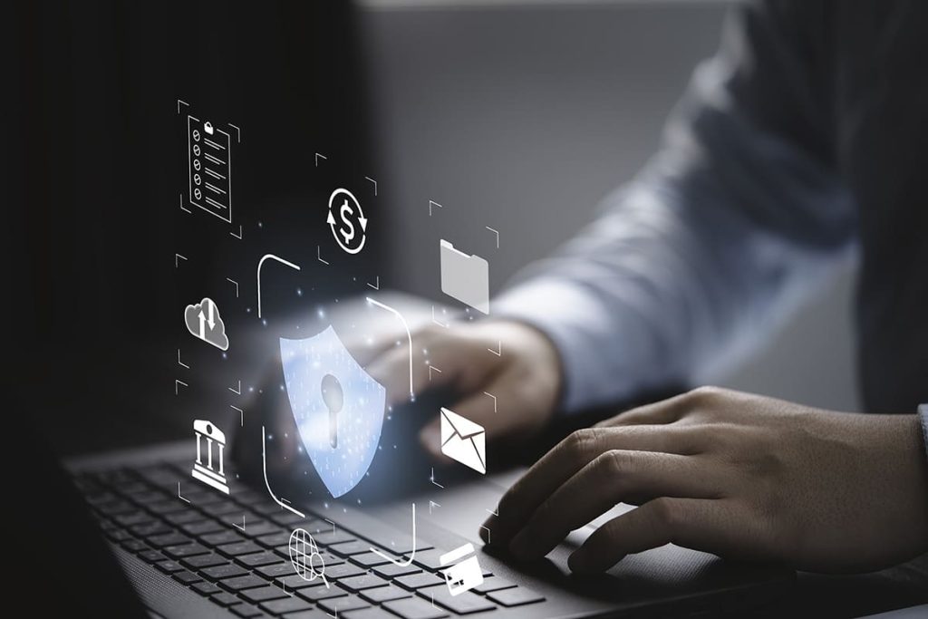 imagen de dos manos escribiendo en un teclado con imágenes virtuales sobre protección de datos