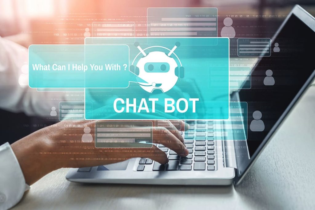 imagen de dos manos escribiendo en un portátil con imágenes virtuales de un chatbot